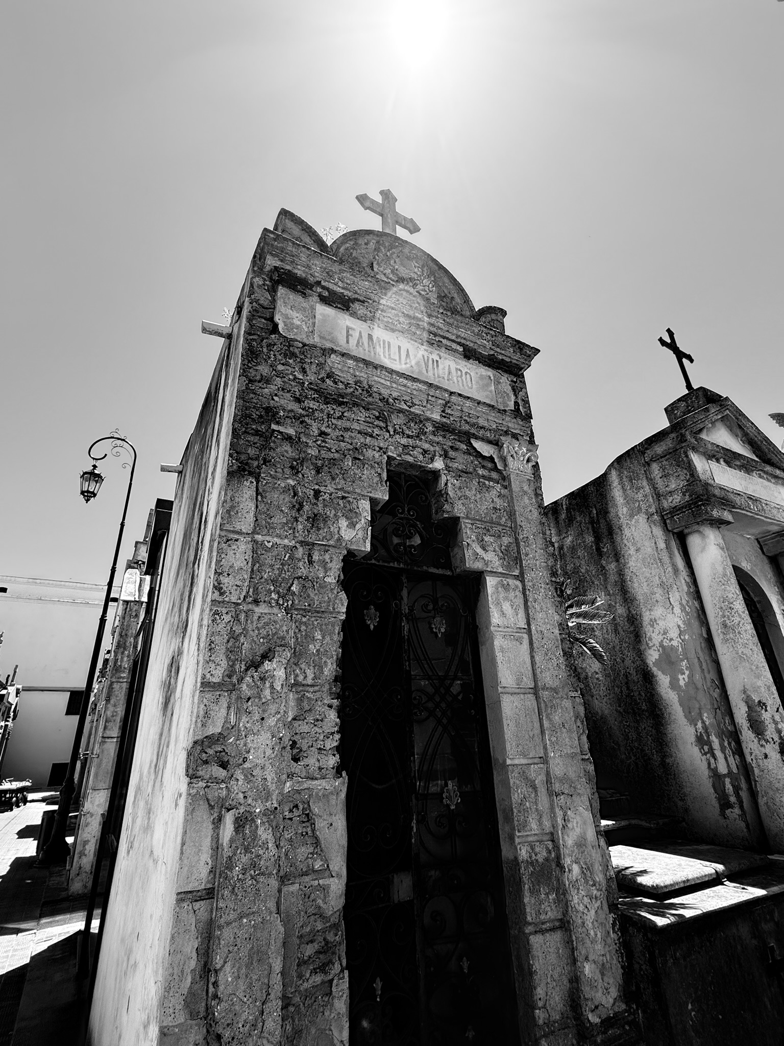 A sunlit stone mausoleum in black and white