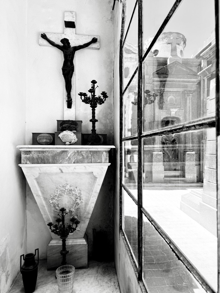 A chapel interior reflected in a window in black and white