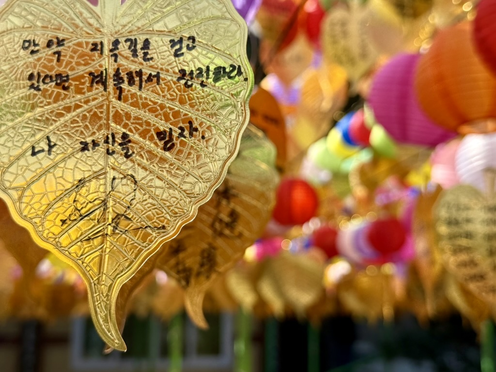 A golden leaf-shaped ornament against colorful lanterns