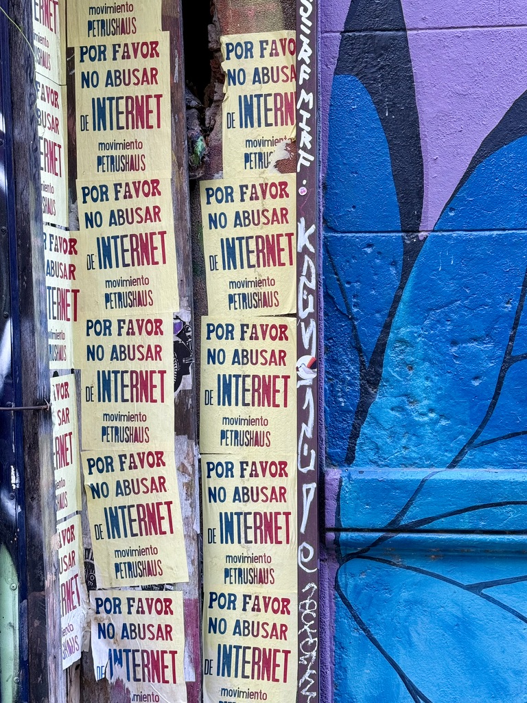 Yellow street posters beside a vivid blue and purple painted wall